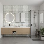 Bright bathroom featuring black and white patterned tiles on the wall, a double vanity with round and rectangular mirrors, an.