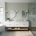 White hexagon tile wall with textured surface, gold fixtures, and two round mirrors in a modern bathroom.