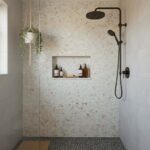 Shower wall featuring elegant mother of pearl shell tiles with a built-in niche for toiletries. Modern design with natural sh.