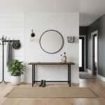 Elegant shell tile wall with mother of pearl accents, round mirror, and minimalist decor in modern entryway.