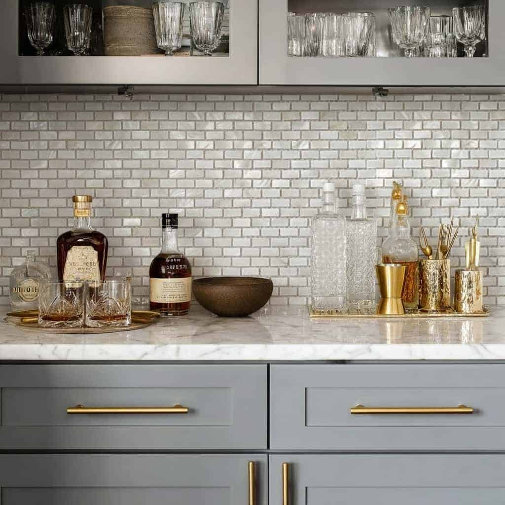 Mother of pearl shell tile backsplash in a stylish kitchen with glassware and bar accessories, adding elegance and a natural.