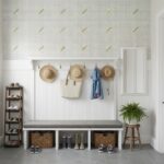Decorative wall with mother of pearl shell tiles and hats, shoes, and a plant in a modern entryway.