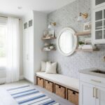Modern entryway with peel and stick wall tile, white cabinetry, and decorative shelves.