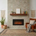 A warm living room featuring a stone fireplace with beige and tan tiles, a wooden mantel, and colorful decorative bottles.
