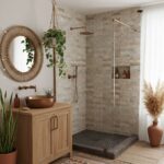 Bright bathroom with beige stone tiles in the shower and a wooden vanity with a copper sink. Natural light and greenery creat.