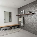 Removable peel and stick tile backsplash on a textured wall, with hooks and a bench in a contemporary home entryway.