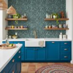 Image of a modern kitchen with peel and stick wall tile backsplash behind the sink area. Blue cabinets and open wooden shelve.