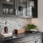Image of a modern kitchen with peel and stick tile backsplash, gray cabinets, and decorative accessories.