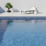 Blue glass tile pool with modern lounge chair and potted plant on a white patio wall.