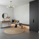 A modern interior featuring a wall decorated with mother of pearl shell tiles, creating a shimmering, elegant accent in a con.