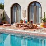 Poolside glass tile backsplash with outdoor seating and decorative cushions.