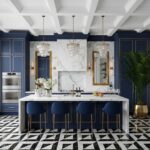 Bright blue cabinetry with marble backsplash and gold accents, featuring a white marble island and black-and-white geometric.