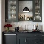 A modern kitchen featuring a sleek backsplash made of mother of pearl shell tiles, complemented by dark cabinetry and elegant.