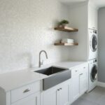 Laundry room with pearl shell tile backsplash and white cabinetry.