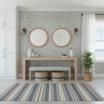 Modern entryway with peel and stick tile backsplash, mirrors, and decor. Bright, airy space with natural light and coastal ac.