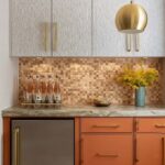 Up of a kitchen backsplash with peel and stick tiles in warm tones, complemented by modern decor and cabinetry.