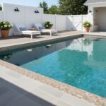 Beautiful backyard featuring a swimming pool with glass tile accents and a cozy outdoor seating area.