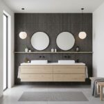 Dark textured tile wall with round mirrors and contemporary bathroom fixtures.