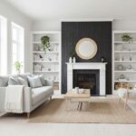 Black textured tile surrounding fireplace with white mantel and neutral-toned furniture.