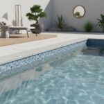 Glass tile pool border with mosaic design and outdoor decor, including potted plants and a mirror, creating a modern poolside.