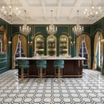 Elegant green and gold bar with marble countertop and ornate decor.