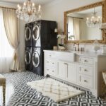 Laundry room with black appliances and white cabinetry, featuring black and white patterned tiles and a plush beige rug.