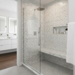 Light gray herringbone tile with textured surface in shower area.