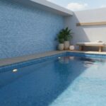 Poolside glass mosaic tile wall and pool with blue glass tiles, modern outdoor design, and relaxing atmosphere.