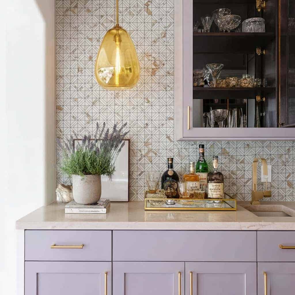 Image of a stylish kitchen featuring peel and stick tile backsplash, purple cabinetry, and elegant decor accents.