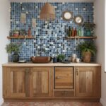 Colorful glass mosaic tile backsplash with blue shades behind a wooden countertop and decor accents.