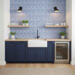 Bright blue glass tile backsplash in a modern kitchen with a white farmhouse sink and navy blue cabinets.