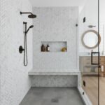 White herringbone tile with textured surface in shower area, complemented by black fixtures and a built-in niche.