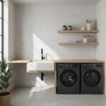 Bright laundry room with white hexagon tiles, black washer and dryer, wooden shelves, and a potted plant.