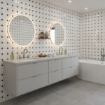 Bright bathroom with black and white patterned tiles, illuminated mirrors, and sleek white vanity.