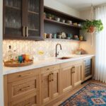 Modern kitchen with peel and stick tile backsplash, wooden cabinets, and open shelving displaying colorful dishes.