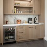 A modern kitchen featuring a backsplash with mother of pearl shell tiles, adding a luxurious and reflective element to the sp.