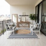 Bright, airy balcony with modern outdoor furniture and decorative accents.