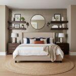 Textured beige wall tile with dark brown wooden shelves, white decor, and a round mirror above the bed.
