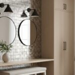 A textured white brick wall with two round mirrors, a white vanity, and decorative plants in a bright, contemporary bathroom.