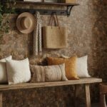 Warm beige and brown textured stone tile wall with a wooden shelf and decorative pillows.