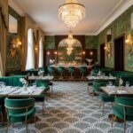 Luxurious restaurant with green velvet chairs, ornate patterned tile floor, and elegant lighting fixtures.