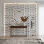 Geometric patterned tile wall in neutral tones with textured surface and round mirror, wooden console, and decorative vases i.