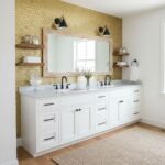 Gold hexagon tile backsplash, smooth white countertop, black fixtures, and wooden accents.