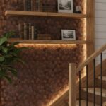 Wooden staircase with black metal railing, warm lighting, and textured wall background.