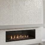 White mosaic tile with a textured, glossy finish surrounding a sleek, linear fireplace.