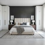 A bedroom featuring a black brick accent wall, white wardrobes, and a cozy bed with neutral bedding. Elegant and minimalist d.