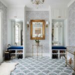 Elegant closet with patterned wallpaper, gold-framed mirror, and plush blue seating areas.