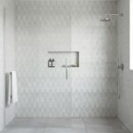 White hexagon tiles with subtle texture in a modern shower.