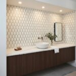 Elegant gold-accented geometric tile wall in a modern bathroom.