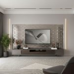 A sleek living room featuring a gray brick wall behind a flat-screen TV, complemented by minimalist decor and soft lighting f.